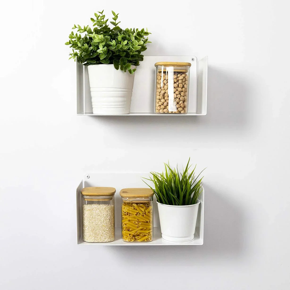 Estantes flotantes blancos de diseño minimalista en cocina con plantas y botes de vidrio.