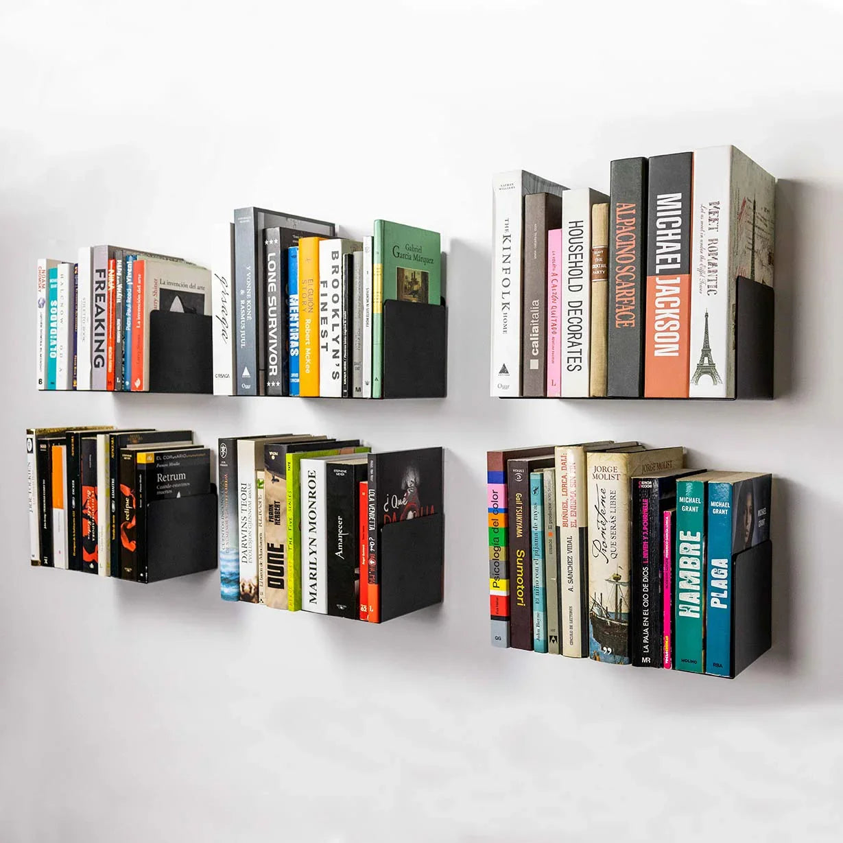 Estantes flotantes negros modernos con libros sobre pared blanca, diseño minimalista.