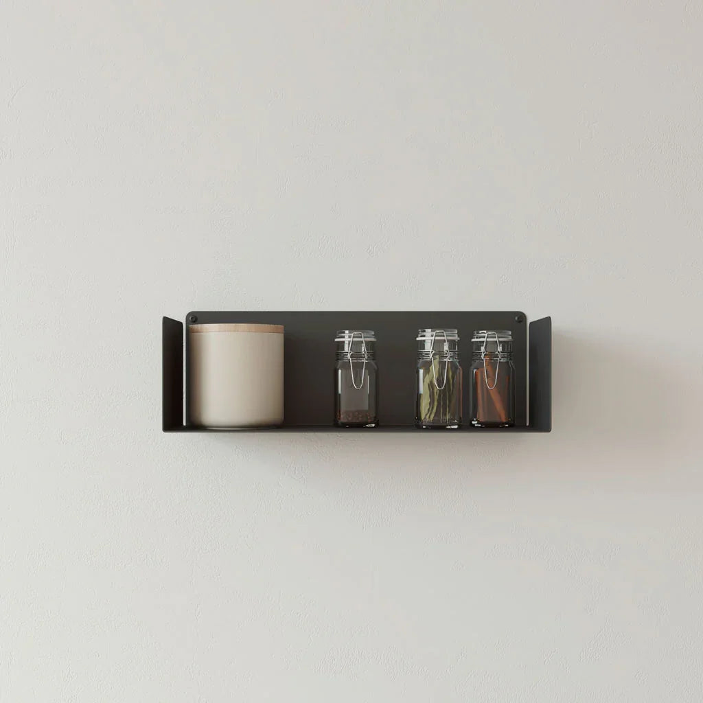 Estante flotante negro minimalista en cocina con botes de especias y tarro decorativo