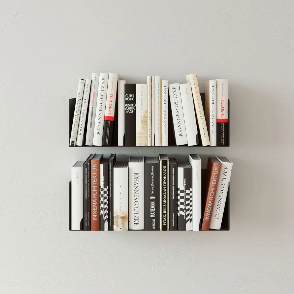 Estantes flotantes de metal negro con libros, diseño minimalista y moderno en pared blanca.