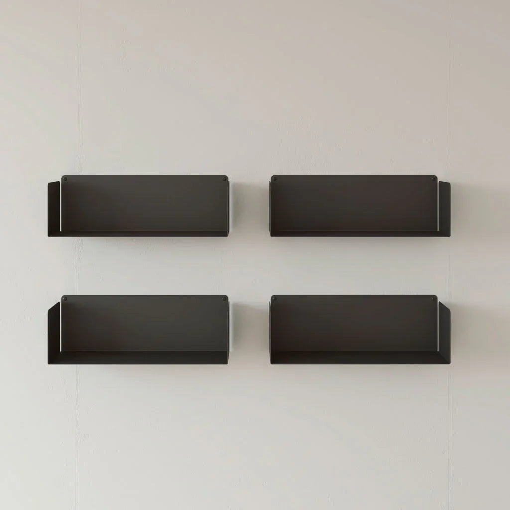 Conjunto de cuatro estantes flotantes negros de diseño minimalista sobre pared blanca