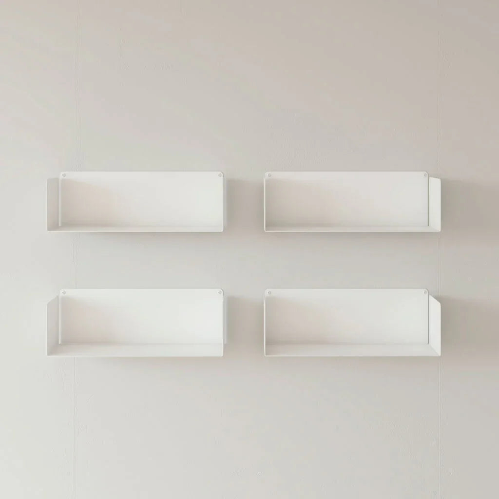 Cuatro estantes flotantes blancos de diseño minimalista instalados en pared blanca