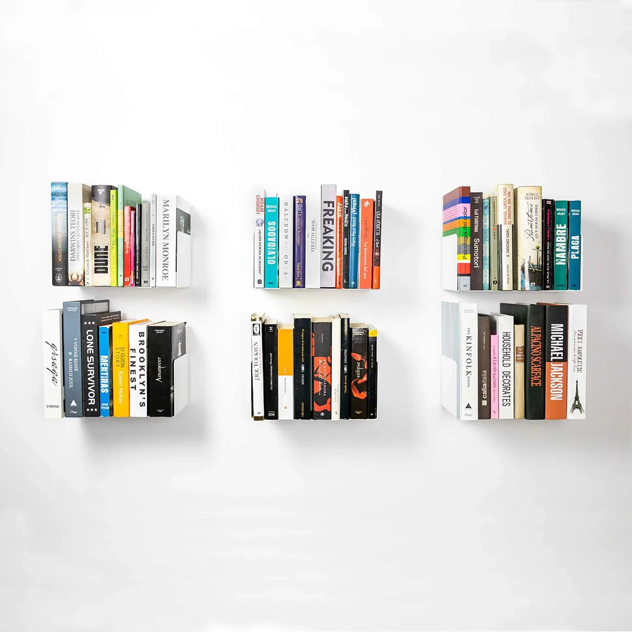 Estantes flotantes blancos minimalistas con libros sobre pared blanca, diseño moderno y funcional.