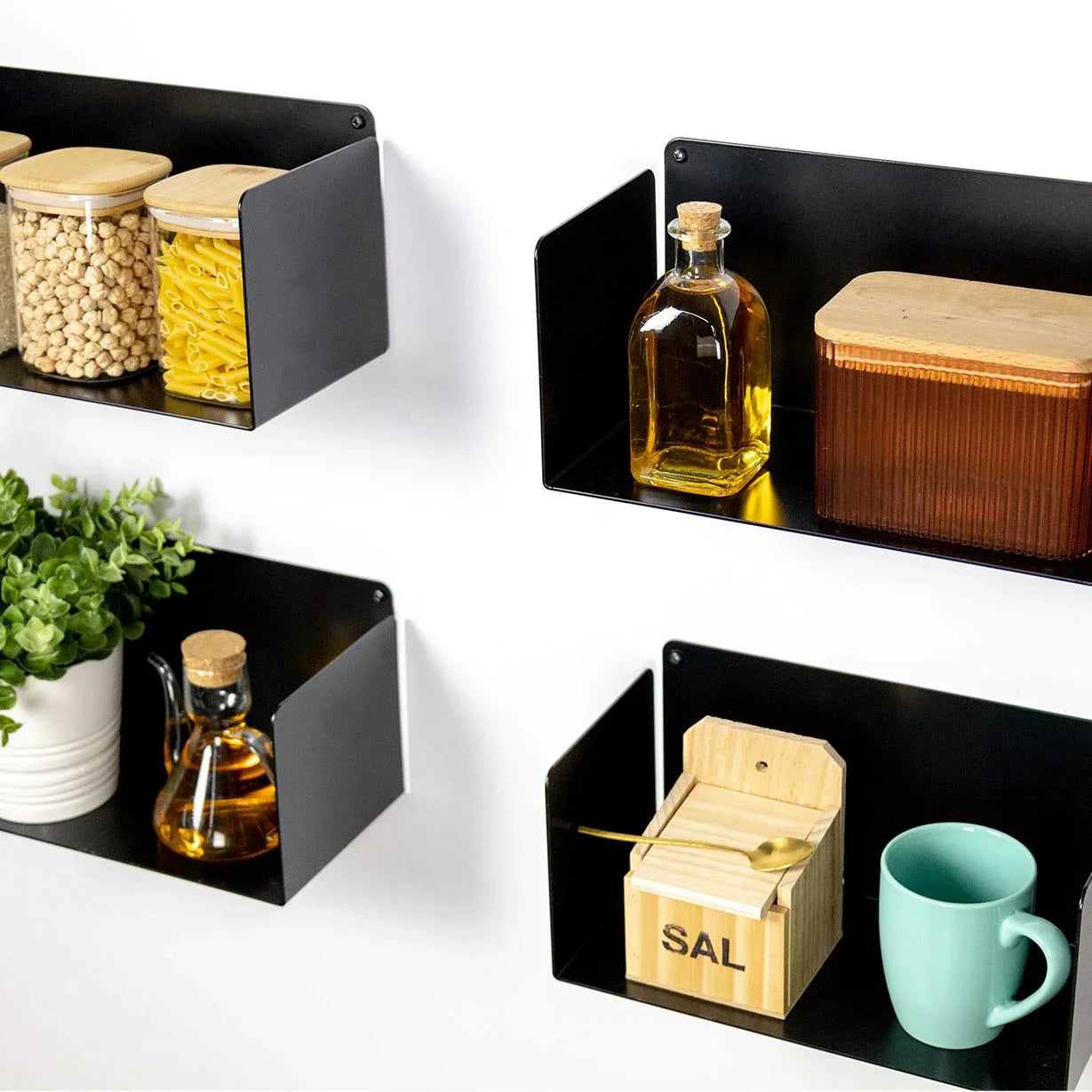 baldas flotantes negras en pared con tarros de alimentos, plantas y utensilios de cocina