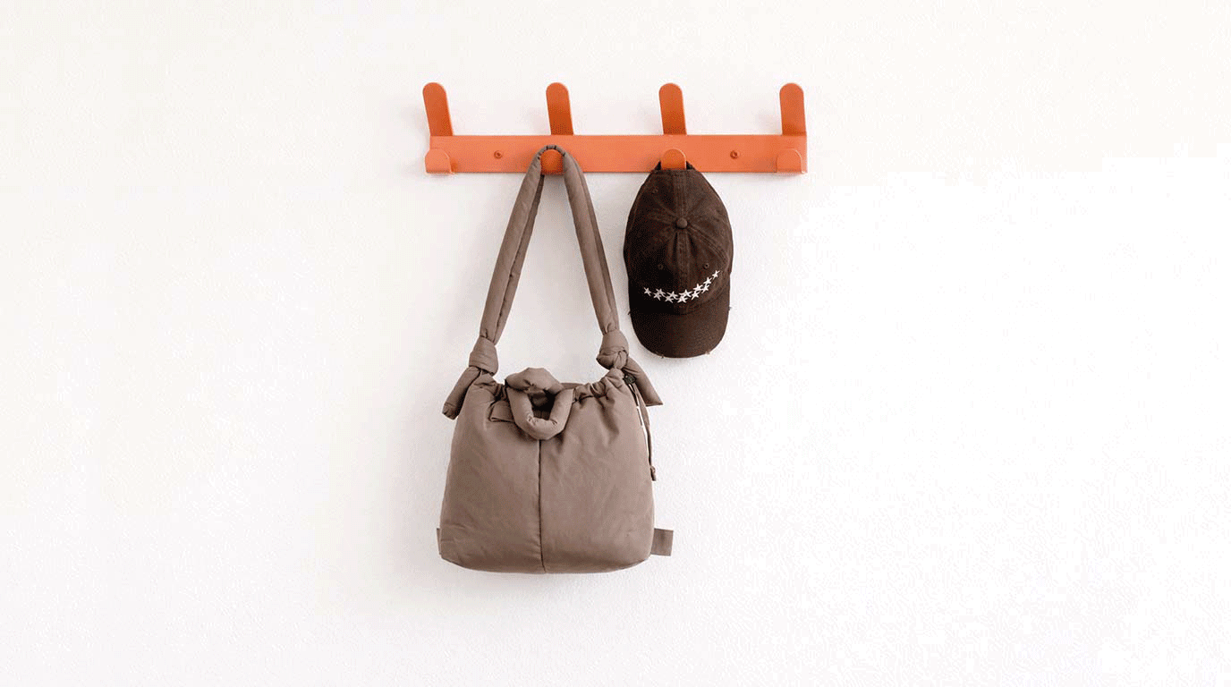 Colgador flotante de pared terracota con bolsos, ropa, gorra, paraguas y chaquetas en pared de recibidor de entrada de casa pequeña