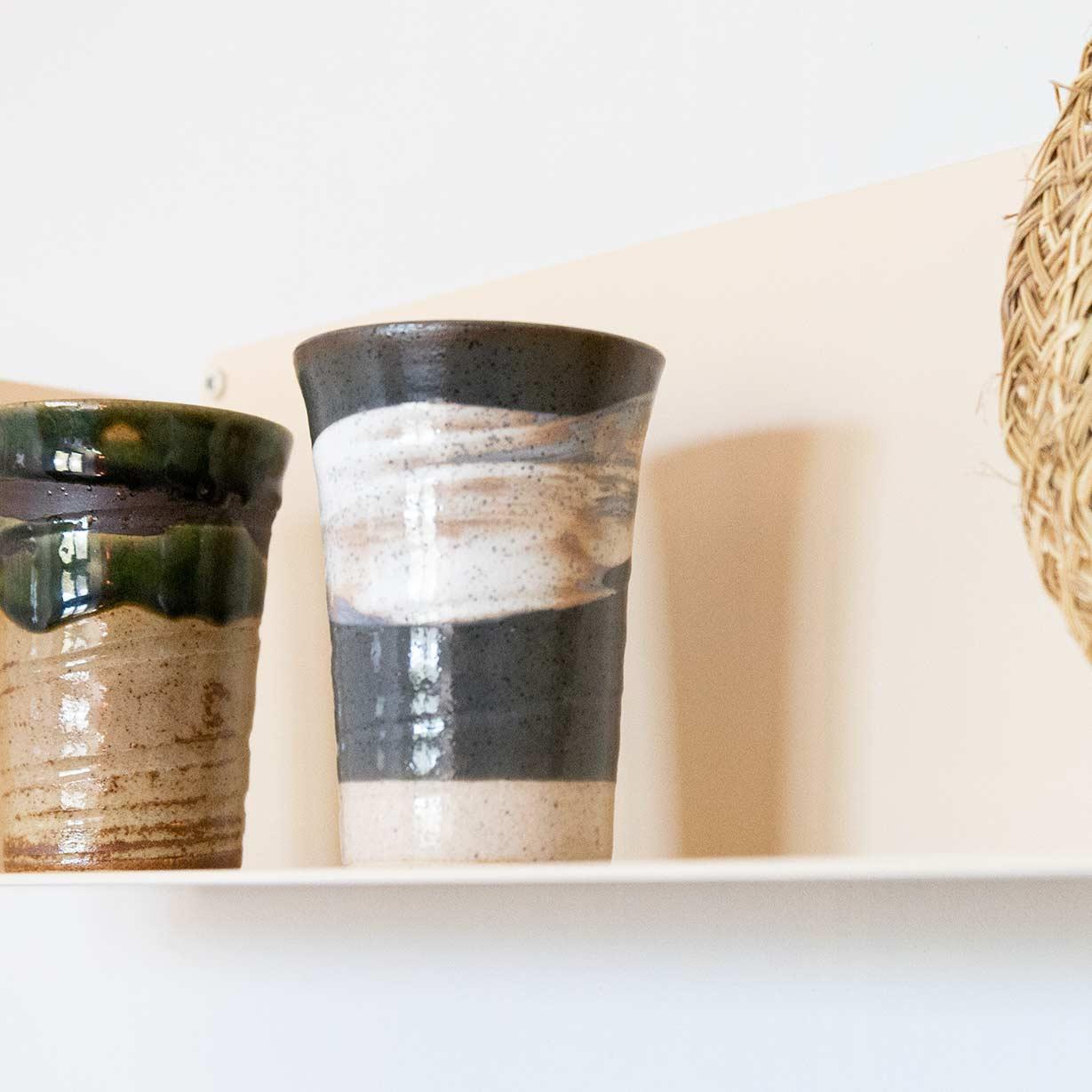 Estante beige de metal con botes y jarrones de cocina