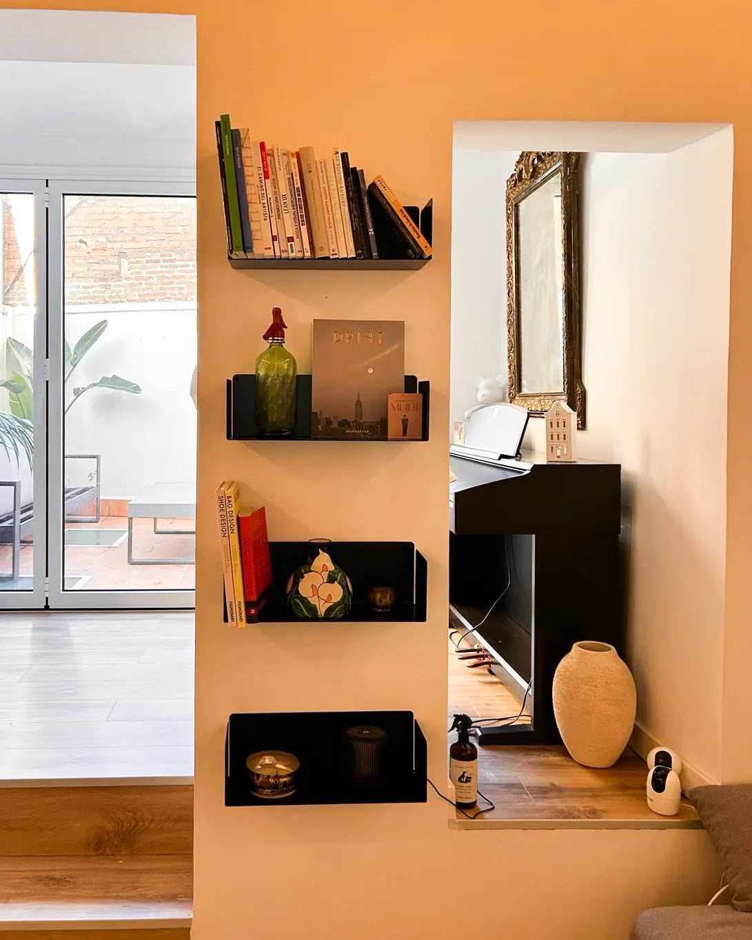 black floating wall shelves with books and decor in a niche, modern design shelves