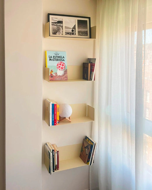 Beige metal floating shelves with books on the wall