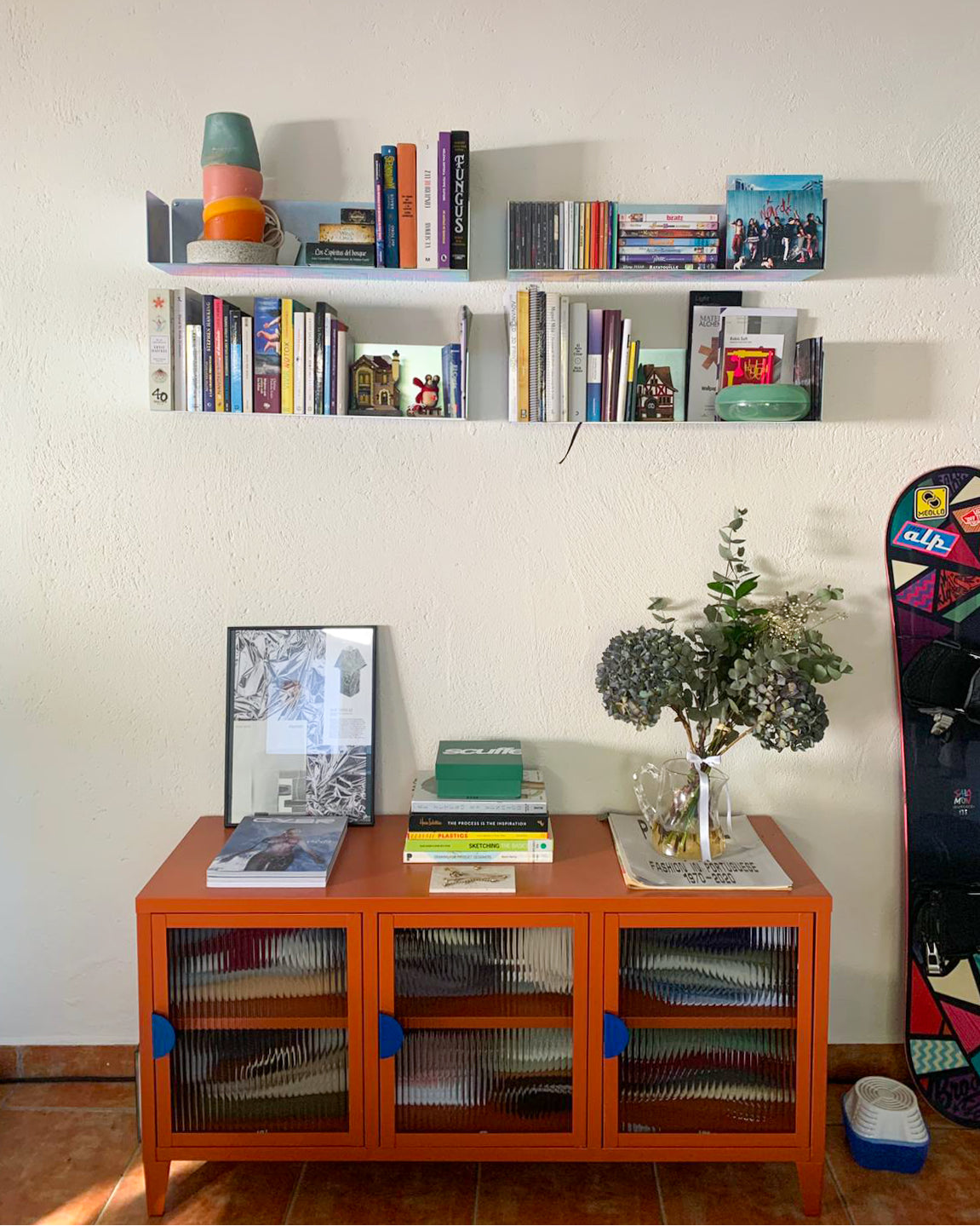 estantería metálica flotante de pared, acabado industrial cromado con libros y decoración en habitación moderna